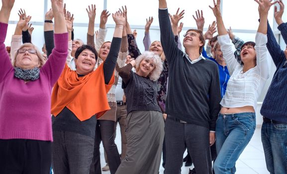 a group of elderly people are reaching up