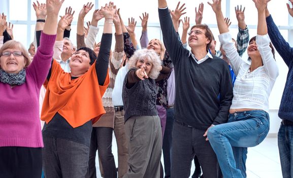 a group of elderly people are reaching up