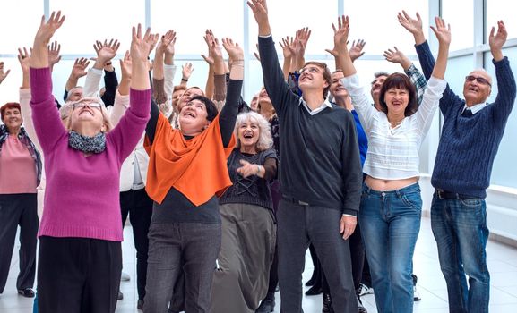 a group of elderly people are reaching up