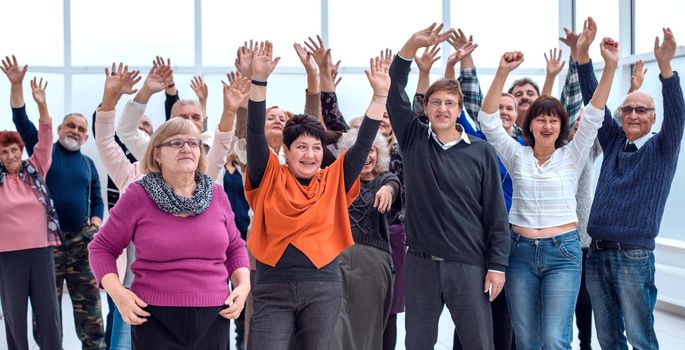 a group of elderly people are reaching up