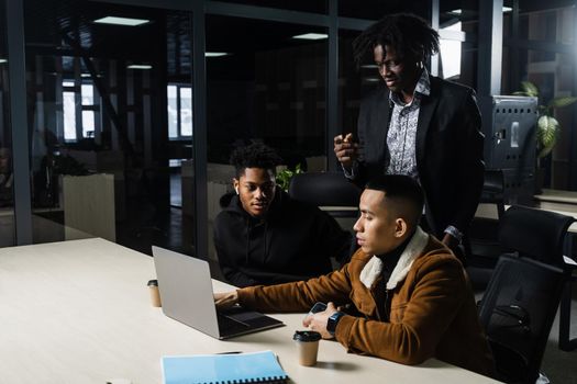 Teamwork online with laptop. Black african and asian colleagues. 3 multiethnic business men watch video conference with colleagues and employer