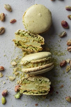 Pistachio flour and green macaroons on a gray background