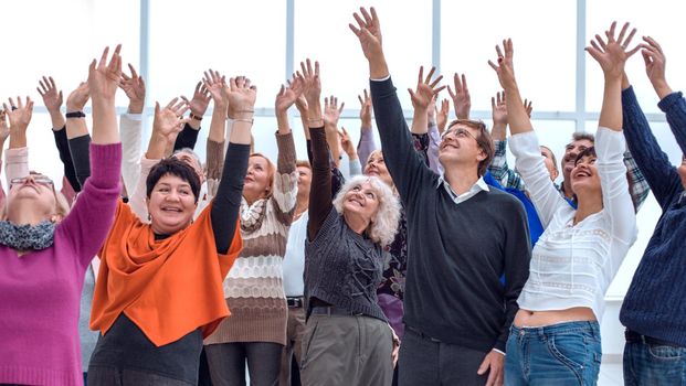 a group of elderly people are reaching up