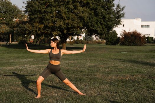 Hand movement of qigong meditation. Attractive girl meditating in the green park