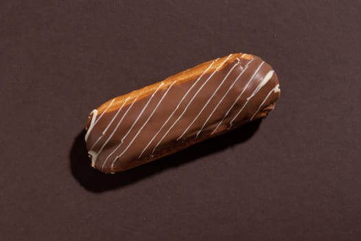 Chocolate eclair on a brown background top view