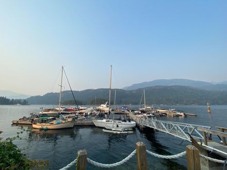 Sailboats at a marina with mountains in the background and blue skies, Egmont, northern British Columbia, Canada