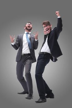 in full growth. two happy dancing young businessmen . isolated on white background.