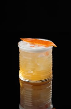 Cocktail in a glass on a black background vertical