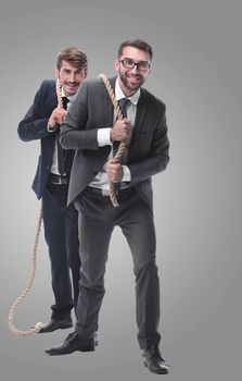 full length . two businessmen pulling a long rope. isolated on white background.