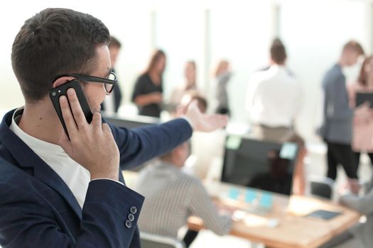 close up. smiling businessman talking on his smartphone. photo with copy space