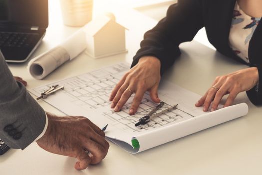 Architect and engineer working with construction drawing project on table in office. Architecture and engineering business concept.