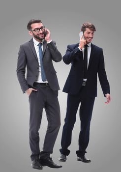 full length . two businessmen using their smartphones . isolated on white background