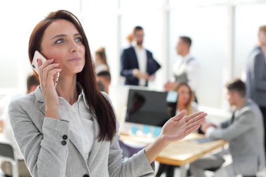 close up. young business woman talking on smartphone in office