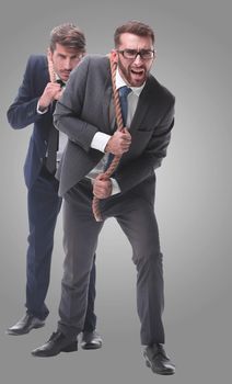 full length . two businessmen pulling a long rope. isolated on white background.
