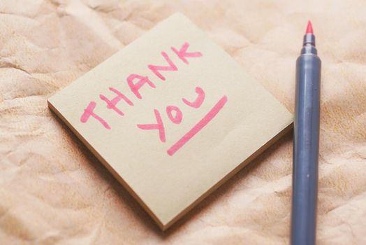 thank you message on a sticky note on old paper ,