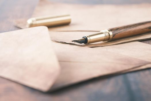 envelope , empty paper and fountain pen on table .