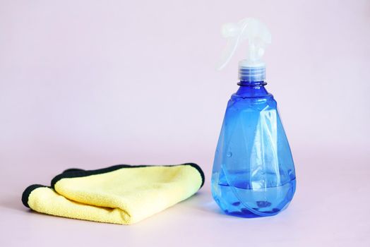 spray bottle and a cleaning cloth on table .