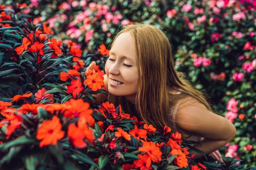 Young woman in a flower greenhouse. Bright tropical flowers..