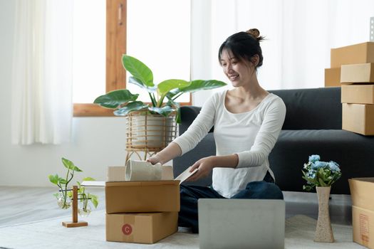 Happy young businessman owner packing order to cardboard box, Young Owner Woman Start up for Business Online. People with online shopping SME entrepreneur or freelance working concept.