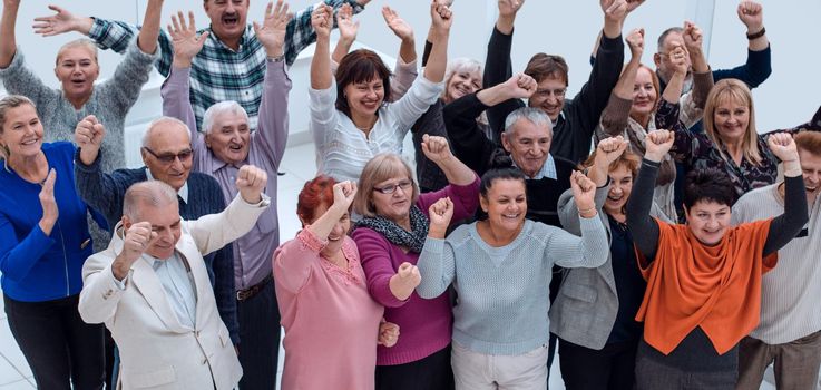 group of elderly friends raised their hands up