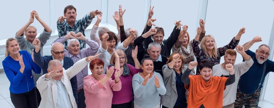 group of elderly friends raised their hands up
