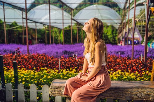 Young woman in a flower greenhouse. Bright tropical flowers..