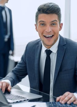 successful young business people working in the office. one looks at the camera and smiles