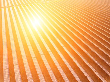 Aerial top view of a solar panels power plant. Photovoltaic solar panels at sunrise and sunset in countryside from above. Modern technology, climate care, earth saving, renewable energy concept