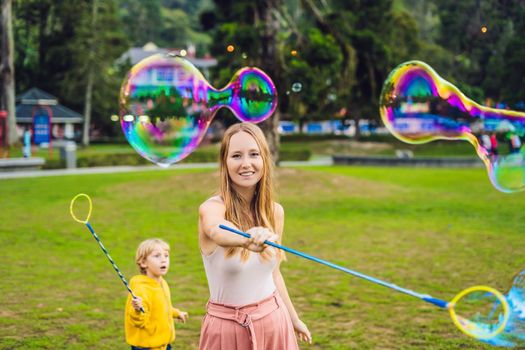 Happy carefree young woman blowing soap bubbles.