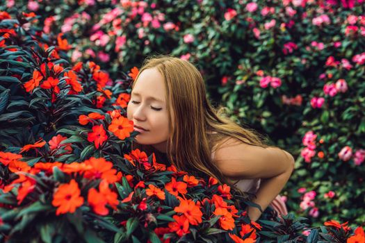 Young woman in a flower greenhouse. Bright tropical flowers..