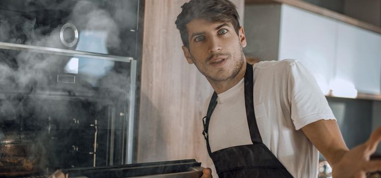 close up. frustrated young man standing near broken oven