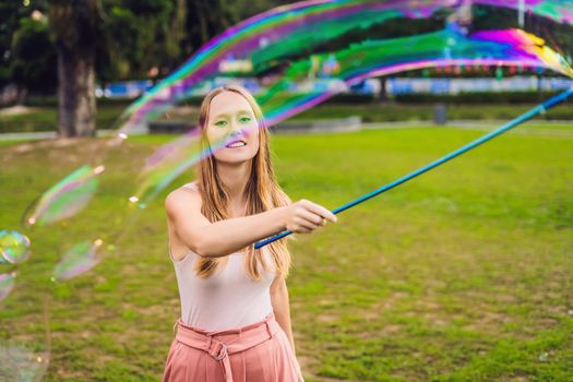 Happy carefree young woman blowing soap bubbles.