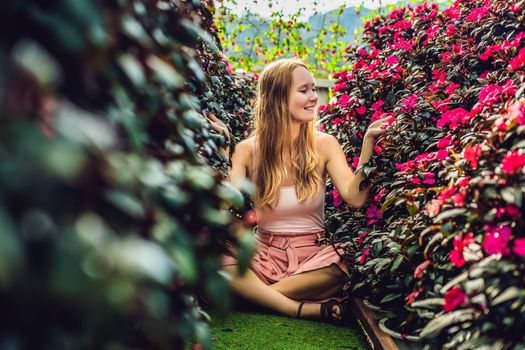 Young woman in a flower greenhouse. Bright tropical flowers..