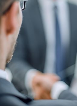 close up.smiling business people shaking hands in office.business concept