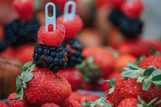 Selective focus. fresh strawberries, raspberries and blackberries in a glass. Summer Beach Food.