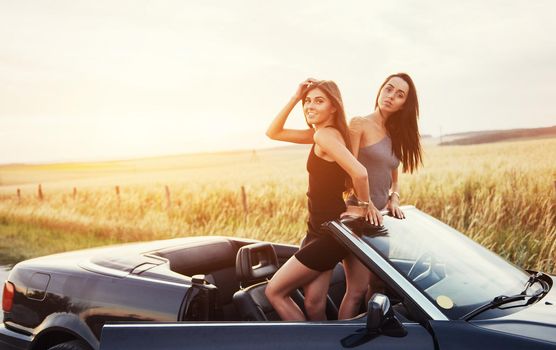 Two women in a black car on the roadside roads.