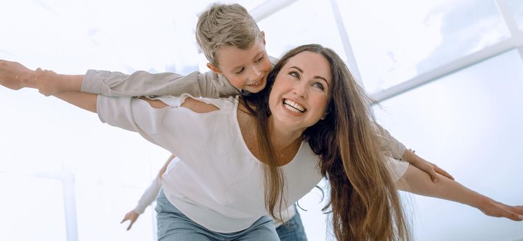 mother plays with her son in a spacious living room.photo with copy space