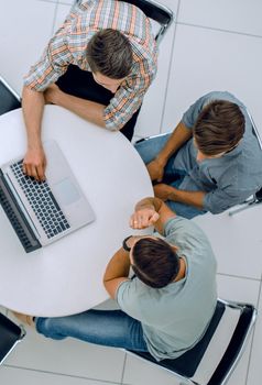 group of people with gadgets sitting at a round table. people and technology