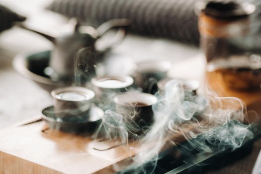 Cups with poured tea before the tea ceremony with incense.