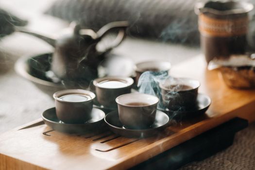 Cups with poured tea before the tea ceremony with incense.