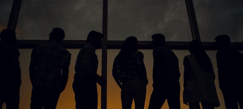 in full growth.modern business team standing near a large window.the concept of teamwork