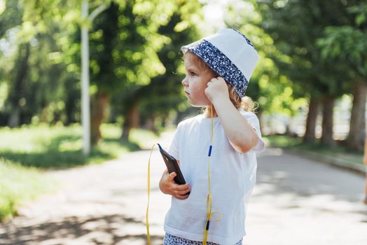 Cute girl listening to music with headphones outdoors.