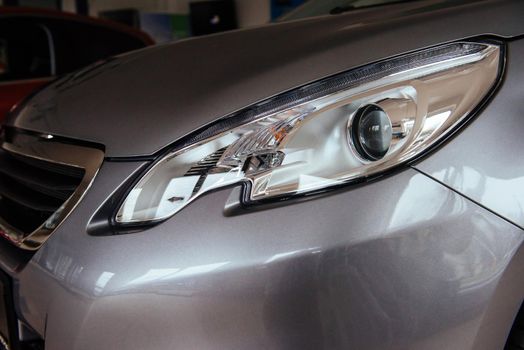 The headlights and the hood of a black sports car.