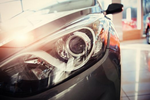 The headlights and the hood of a black sports car.