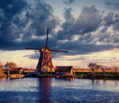 Colorful spring day with traditional Dutch windmills canal in Rotterdam. Wooden pier near the lake shore. Holland. Netherlands.