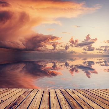 Beautiful sunset over sea with reflection in water, majestic clouds in the sky