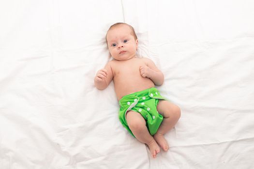 Reusable diaper on the baby copy space . An article about reusable diapers. Saving on diapers. Concern for the environment. Eco-products. Breathable diapers with buttons. High quality photo