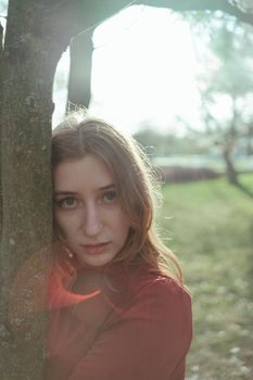 portrait of a girl in backlight in the park in the spring close-up