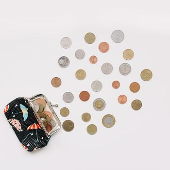 Open purse with different coins isolated on white background top view. Financial crisis, poverty, lack of money
