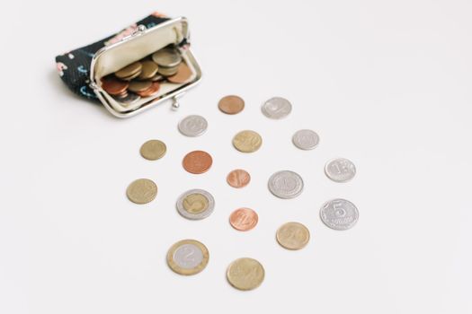 Open purse with different coins isolated on white background top view. Financial crisis, poverty, lack of money